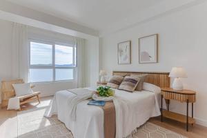 a white bedroom with a large bed and a window at Blue Ocean Deluxe in Portonovo