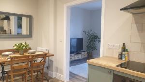 eine Küche und ein Esszimmer mit einem Tisch und einem TV in der Unterkunft The Meads in Ilfracombe
