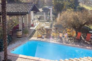 a swimming pool in front of a house with a garden at Magnifico Roero Relax Tre Camere in Canale
