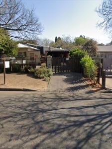 una casa con una valla de madera y un camino de entrada en Ravens Nest, en Bloemfontein 12 fotos más