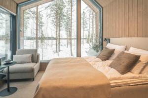 una camera da letto con un letto e una sedia e una grande finestra di Tyven Resort a Sirkkakoski