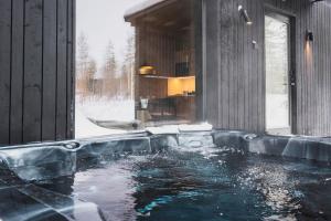 a jacuzzi tub in a room with snow at Tyven Resort in Sirkkakoski