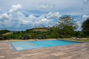 una piscina con un castello sullo sfondo di Borgo Campassini, Monteriggioni a Monteriggioni