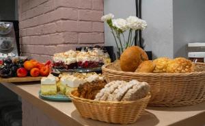 a table with baskets of bread and desserts on it at HOLA GDYNIA in Gdynia