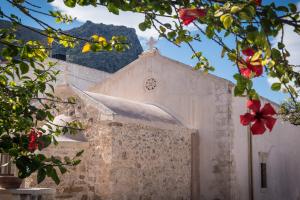 a white building with a clock on the side of it at Bianca Doma Adults Only by Estia in Hersonissos +13 photos