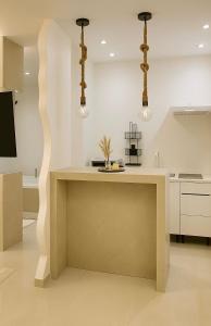 een keuken met een tafel en twee hanglampen bij Suite Oléa & Private Jacuzzi in Saint-Denis