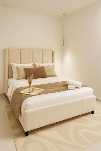 een witte slaapkamer met een groot wit bed en een tafel bij Suite Oléa & Private Jacuzzi in Saint-Denis