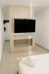 een woonkamer met een flatscreen-tv aan de muur bij Suite Oléa & Private Jacuzzi in Saint-Denis