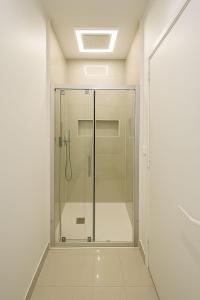 een douche met een glazen deur in een badkamer bij Suite Oléa & Private Jacuzzi in Saint-Denis
