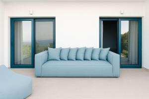 a blue couch in a room with windows at Fask Villa Zakynthos, Infinity Views & Serenity by Villa Mana Gers in Akrotiri