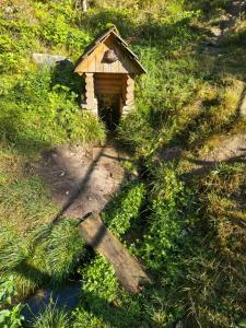 una pequeña casa de pájaros sentada en el césped en Apartmány Javorek, en Sněžné