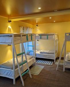 3 letti a castello in una camera con parete gialla di Piti khangpa a Jāmb
