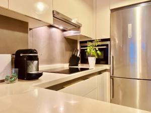 a kitchen with a stainless steel refrigerator at Orzan Beach Surf Apartment in A Coruña