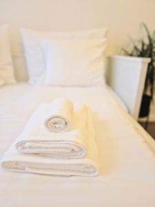 una pila di asciugamani bianchi appoggiata su un letto di Apartment Natali a Karlovy Vary