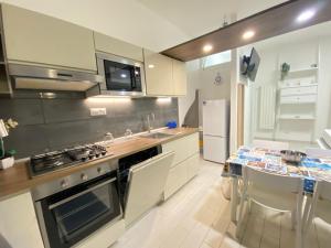 a kitchen with white cabinets and a stove top oven at Casa sinuessa in Gaeta