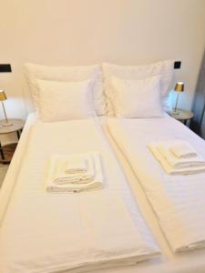 un letto bianco con due asciugamani sopra di Apartment Natali a Karlovy Vary Altre 34 foto