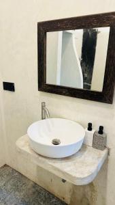 a white sink in a bathroom with a mirror at Mango Hous in Ahangama Central