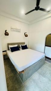 a bedroom with a large bed with blue pillows at Mango Hous in Ahangama Central