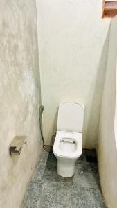 a small bathroom with a toilet in a stall at Mango Hous in Ahangama Central