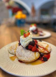 フリーデク・ミーステクにあるHotel Korekのベリーとホイップクリームを添えたパンケーキ2皿