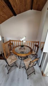 un tavolo con tre sedie e un vaso con dei fiori sopra di La tête dans les étoiles a Ruffec Altre 3 foto