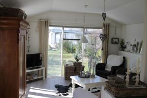 un soggiorno con un divano e una TV di Weideveld 60 Michelle a Den Burg