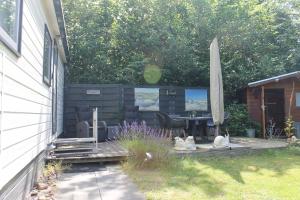 un patio con un tavolo e un ombrellone di Weideveld 60 Michelle a Den Burg