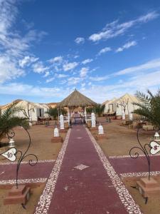 a walkway leading to a compound with tents at DesertGlow camp in Merzouga +10 photos