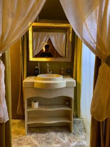 a bathroom with a sink and a mirror at DesertGlow camp in Merzouga