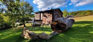 Un tronco y una silla frente a una cabaña en Apartmány Javorek, en Sněžné
