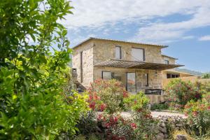 a stone house with flowers in front of it at Romantic Lemon Grove Cottage with Private Pool - Oporto Lemon Farm, near Porto in Valpedre
