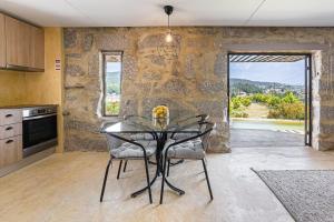 a dining room with a table and a stone wall at Romantic Lemon Grove Cottage with Private Pool - Oporto Lemon Farm, near Porto in Valpedre