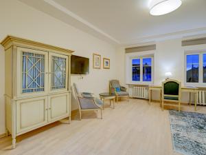 ein Wohnzimmer mit Stühlen, einem Tisch und einem Schrank in der Unterkunft Old Town Doma View 1BR Stays in Riga
