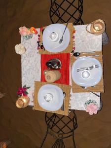 a table with white plates and utensils on it at DesertGlow camp in Merzouga +9 photos