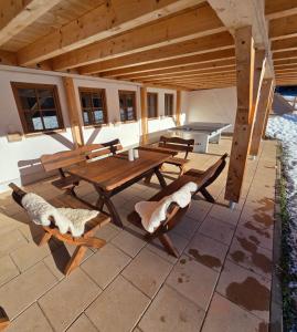 ein hölzerner Picknicktisch und Stühle auf einer Terrasse in der Unterkunft Sonneckalm in Berchtesgaden in Berchtesgaden