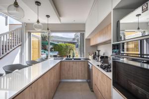 克乌尔伯姆斯特兰德Seagull View Sand的一个带木制橱柜和大窗户的厨房