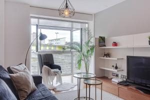 a living room with a couch and a tv at Blue Ocean Apartment in A Coruña
