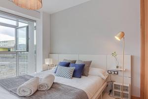 a bedroom with a large white bed with blue pillows at Blue Ocean Apartment in A Coruña
