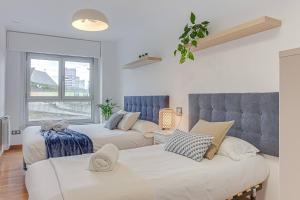 a bedroom with two beds and a couch at Blue Ocean Apartment in A Coruña +5 photos