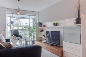 a living room with a flat screen tv and a couch at Blue Ocean Apartment in A Coruña