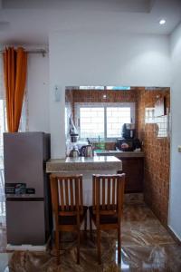 cocina con encimera con 2 sillas y nevera en InfiniStay, en Abiyán 8 fotos más
