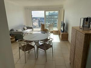 a living room with a table and chairs and a couch at Residence Wembley with sea view in Middelkerke
