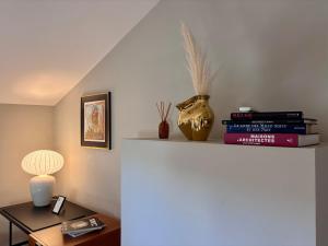 une étagère avec des livres et une table avec une lampe dans l'établissement Merci Papa Merci Maman, à Maussane-les-Alpilles