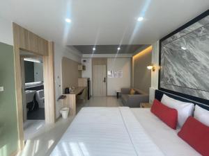 Un dormitorio con una gran cama blanca con almohadas rojas. en Bangkok Mystay Hotel Rangsit, en Thanya Buri