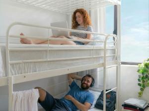 a man and a woman sitting on top of bunk beds at Hostel Las Palmas by Youroom in Las Palmas de Gran Canaria