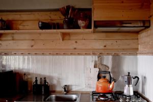 a kitchen sink with an orange tea kettle on it at For-Rest Lodge de Hilkensberg in Broekhuizen