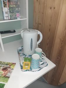 贝尔格新城Chambres d'hôtes Des couleurs et des Mots的一张桌子,上面有咖啡壶和杯子 更多23张照片