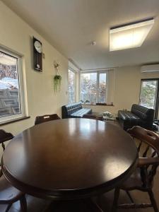 een woonkamer met een houten tafel en stoelen bij 青山ハウス in Otaru