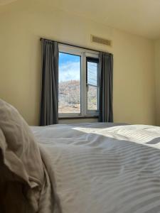 een slaapkamer met een bed en een groot raam bij 青山ハウス in Otaru