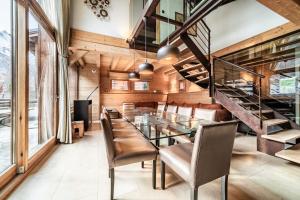 Chalet Inari Chamonix - by EMERALD STAY في شامونيه مون بلان: غرفة طعام مع طاولة وكراسي زجاجية